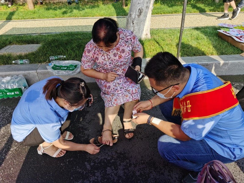 志愿者为脚受伤的考生家长包扎伤口（郑州十一中附近）